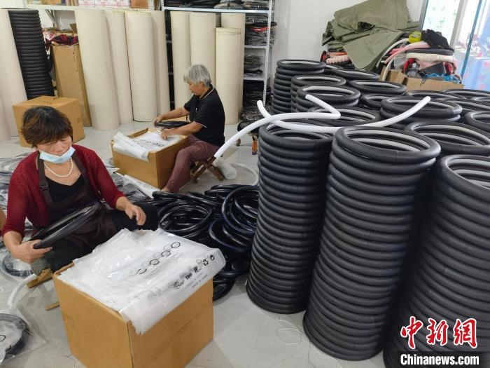 圖為村民在汽車飾品企業(yè)生產(chǎn)車間中工作。　呂子豪 攝