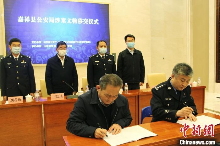 山東博物館館長(zhǎng)鄭同修和嘉祥縣人民政府副縣長(zhǎng)、公安局局長(zhǎng)趙健簽署移交協(xié)議?！≮w曉 攝