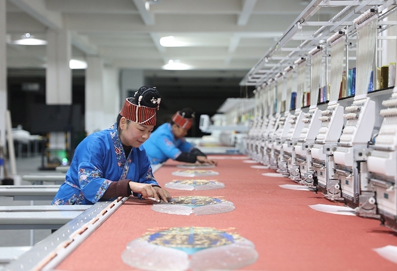 2023年2月13日，貴州省黔東南苗族侗族自治州施秉縣工業(yè)園區(qū)，工人在機(jī)繡車間作業(yè)。