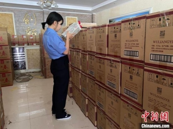 資料圖為檢察人員核對查獲的假冒品牌白酒。青海省人民檢察院供圖