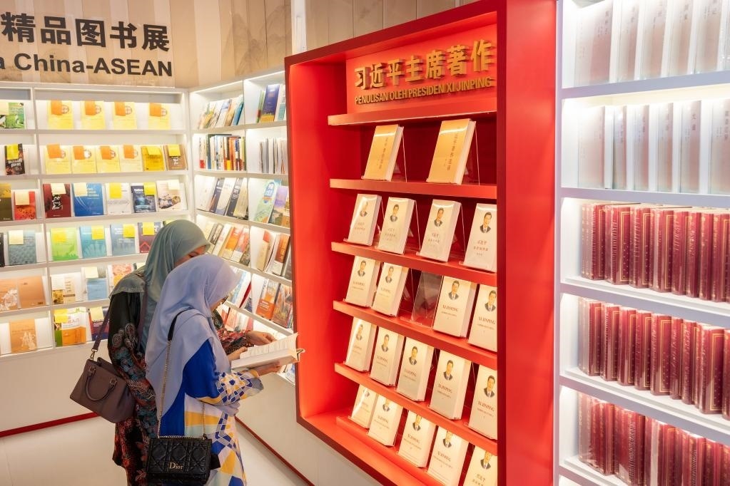 5月30日，兩名讀者在馬來西亞吉隆坡國際書展中國主賓國活動現(xiàn)場閱讀習(xí)近平主席著作。新華社記者朱煒攝