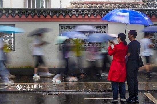 6月7日，在浙江省2023年普通高校招生考試鎮(zhèn)海中學(xué)考點(diǎn)，家長冒雨目送子女進(jìn)入考場。人民網(wǎng) 章勇濤攝