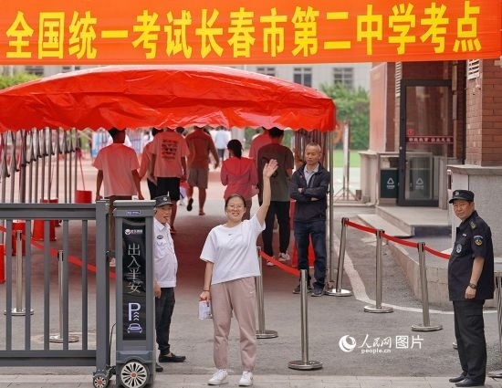 6月7日，在長春市第二中學(xué)考點(diǎn)，一名考生信心滿滿進(jìn)入考場，并與家長揮手致意。人民網(wǎng)記者 李洋攝