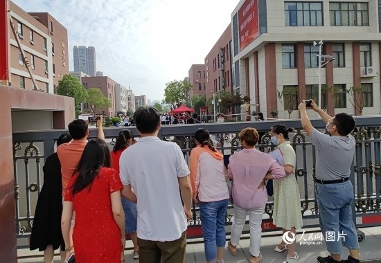 6月7日，武漢市第三中學(xué)考點(diǎn)，考生進(jìn)場后，家長在柵欄外用手機(jī)拍攝自己的孩子。人民網(wǎng)記者 郭婷婷攝