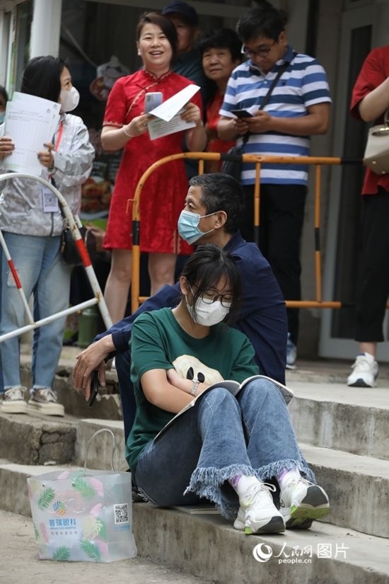 6月7日，沈陽市第一中學(xué)，學(xué)子靠在父親身邊做最后的沖刺。人民網(wǎng) 周頌雪攝