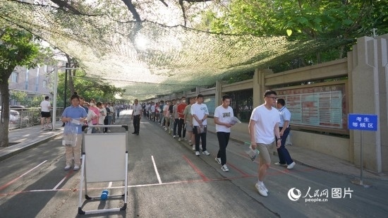 6月7日，烏魯木齊市第七十中學(xué)門口，考生們有序進(jìn)入考場。人民網(wǎng) 李欣洋攝
