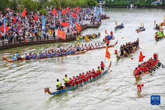 6月23日，在貴州省黔東南苗族侗族自治州施秉縣舉行的獨(dú)木龍舟節(jié)上，獨(dú)木龍舟進(jìn)行水上巡游。