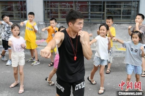 圖為大學(xué)生志愿者在組織孩子們參加體育健身活動(dòng)。廖光福 攝