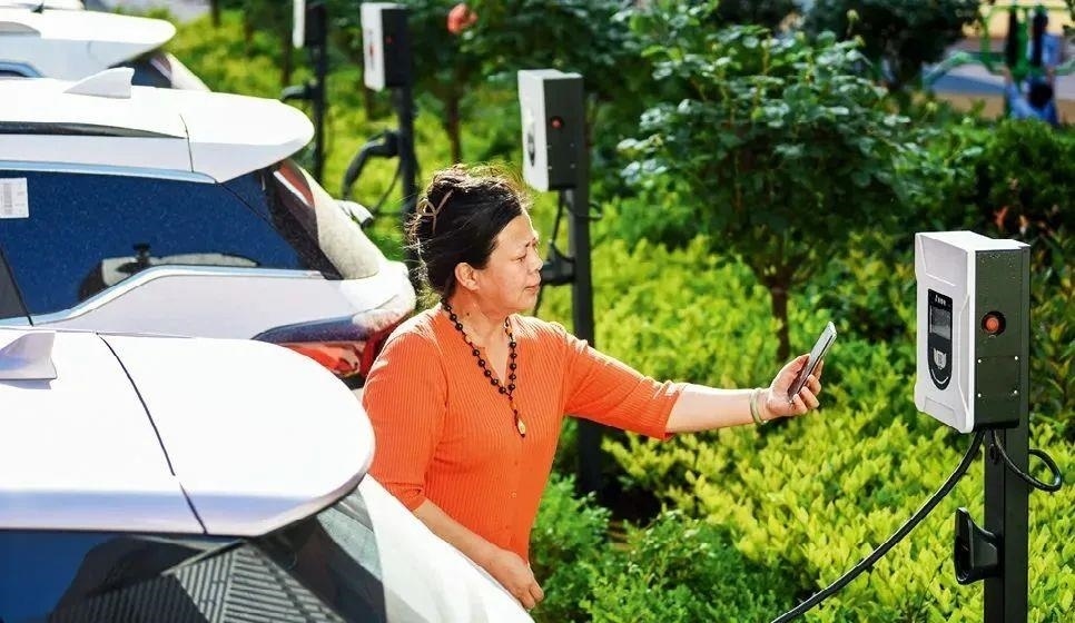 2023年5月24日，山東省膠州市新立街小區(qū)內(nèi)一位居民使用電動汽車充電樁掃碼充電。該小區(qū)加裝各類智慧設(shè)備，打造“智慧社區(qū)”，為居民生活帶來便利。