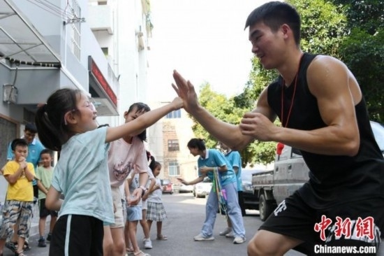 圖為大學(xué)生志愿者在組織孩子們參加體育健身活動(dòng)。廖光福 攝