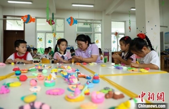 在肥西縣山南鎮(zhèn)中心幼兒園，孩子們?cè)诶蠋煹闹笇?dǎo)下做彩色泥塑。陳家樂(lè) 攝