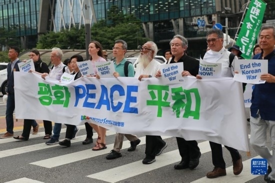 7月22日，在韓國首爾，人們手舉標語參與反戰(zhàn)游行。新華社發(fā)（楊暢 攝）