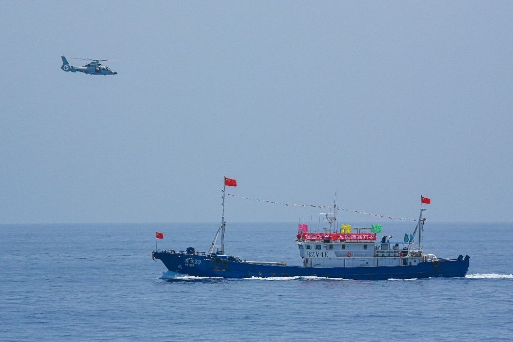 ↑中國海軍第40批護航編隊中的艦載直升機在被護船只周邊海域巡邏警戒（2022年6月4日攝）。新華社發(fā)（唐文 攝）