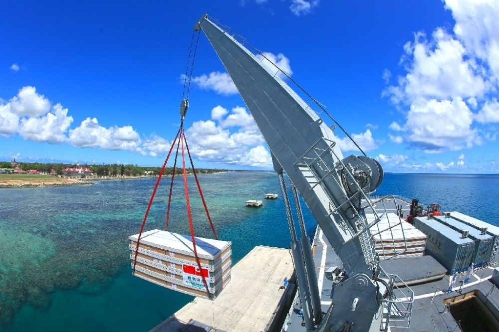 ↑赴湯加執(zhí)行運送救災物資任務的中國海軍艦艇編隊在努庫阿洛法港卸載移動板房（2022年2月19日攝）。新華社發(fā)（薛成清 攝）