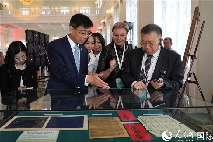 中俄圖書館論壇嘉賓共同參觀由俄羅斯國立列寧圖書館舉辦的館藏中國古籍善本圖書展。人民網(wǎng)記者 隋鑫攝）