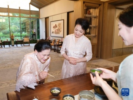 7月27日下午，國家主席習(xí)近平夫人彭麗媛在四川成都會見陪同印度尼西亞總統(tǒng)佐科來華出席第31屆世界大學(xué)生夏季運動會開幕式并訪華的總統(tǒng)夫人伊莉亞娜。這是彭麗媛邀請伊莉亞娜觀看茶藝表演，并同伊莉亞娜親切茶敘。新華社記者 丁林 攝