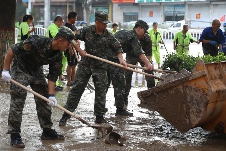 武警河北總隊保定支隊官兵在涿州市城西107國道沿線清理淤泥（8月5日攝）。新華社發(fā)（王紅強 攝）