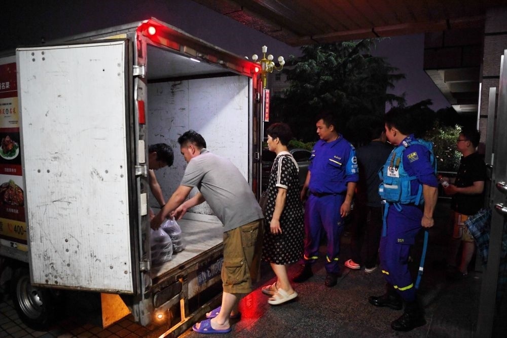 河北省涿州市職教中心安置點的工作人員在運送飯菜，準(zhǔn)備發(fā)放給安置群眾（8月1日攝）。新華社記者 牟宇 攝