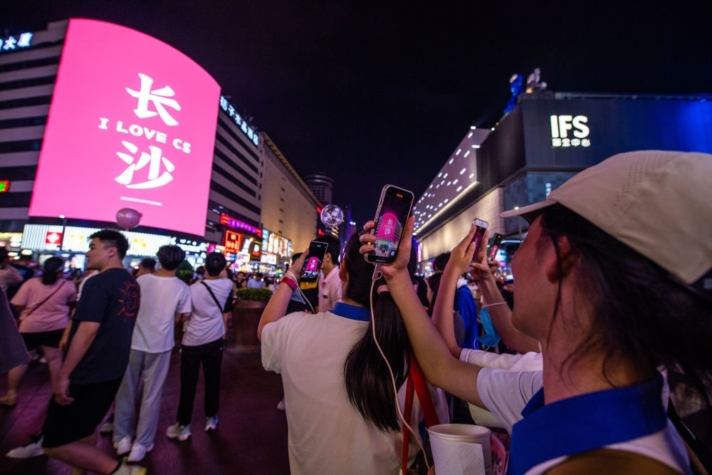  游客在長(zhǎng)沙市天心區(qū)黃興路步行街打卡、拍照（6月7日攝）。新華社記者 陳思汗 攝