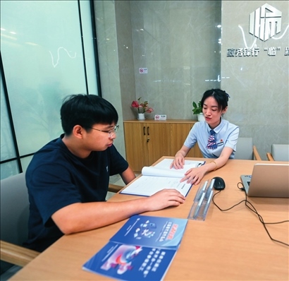 在杭州市臨安區(qū)政務服務中心的“為企服務中心”，黨員志愿者（右）解答企業(yè)主的疑問（2023年7月7日攝）。徐昱攝/本刊