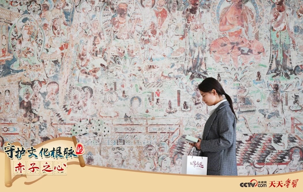 2023年4月25日，敦煌研究院文物數(shù)字化保護(hù)團(tuán)隊(duì)創(chuàng)意營(yíng)銷(xiāo)人員廖雪婷從一幅高保真復(fù)制壁畫(huà)前走過(guò)。