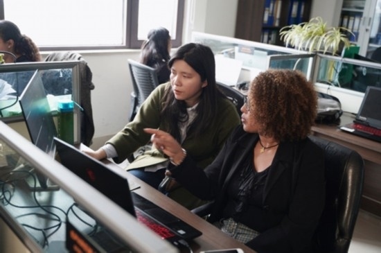 梅德哈妮（右）與中國同事討論設(shè)計方案。受訪對象供圖