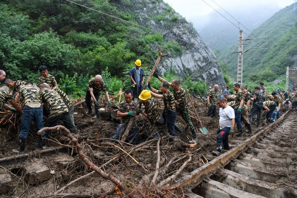 8月1日，在北京市門頭溝區(qū)水峪嘴村附近一段被阻斷的鐵路線上，中鐵六局工作人員在清理軌道上的雜物，全力恢復(fù)交通。新華社記者 鞠煥宗 攝