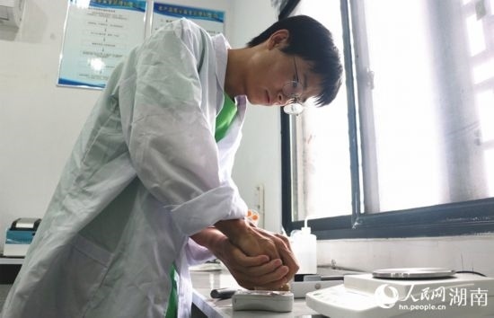 吳健筆在獼猴桃科技小院實(shí)驗(yàn)室測(cè)量水果糖分。 人民網(wǎng)記者 劉賓攝