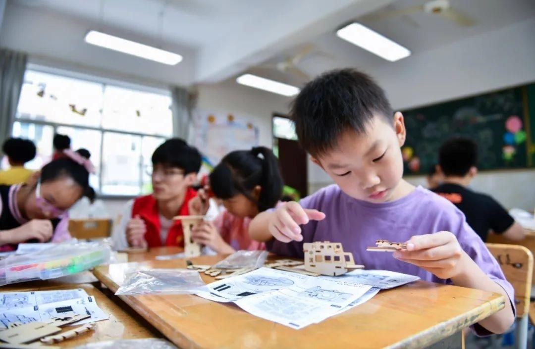 △今年7月，在浙江余姚市舜北小學(xué)暑托班內(nèi)，孩子們制作太陽能科學(xué)實(shí)驗(yàn)裝置。