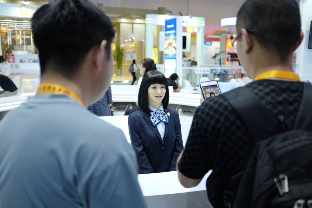 9月1日，媒體記者在國家會議中心與服務(wù)機器人互動。新華社記者 劉夢琪 攝