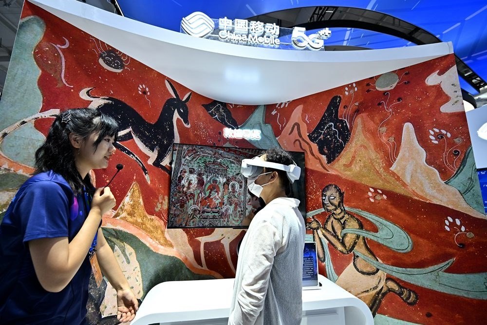 9月3日，一名參觀者在首鋼園中國移動展臺體驗(yàn)基于AR/VR特效的敦煌導(dǎo)覽，沉浸式感受敦煌壁畫的魅力。新華社記者 李鑫 攝