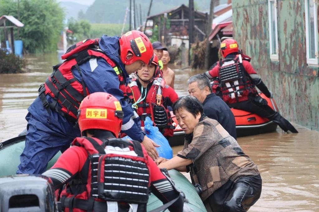 8月4日，在黑龍江省尚志市一面坡鎮(zhèn)萬(wàn)山村，哈爾濱市森林消防支隊(duì)的消防員在解救被困村民。新華社發(fā)