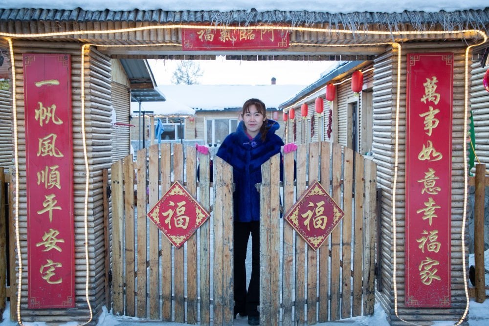 北極村民宿經(jīng)營者史瑞娟在門前迎候入住的游客（2023年1月7日攝）。