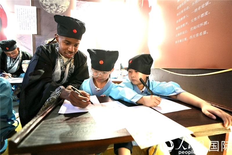 圖為選手與同學(xué)們一起寫書法。人民網(wǎng) 盧鵬宇攝