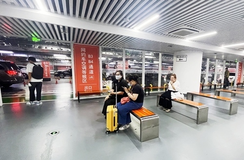 旅客在網(wǎng)約車空調(diào)等候區(qū)等候網(wǎng)約車。人民網(wǎng)記者 喬雪峰攝