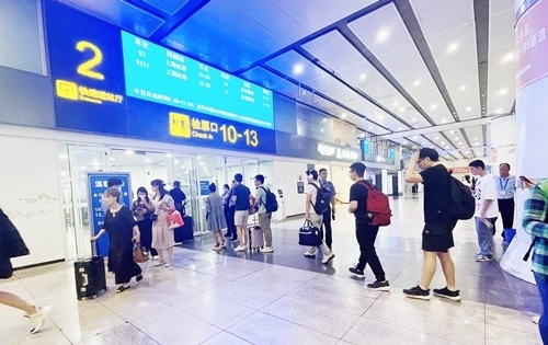 在快速進(jìn)站廳前排隊等待檢票的旅客。人民網(wǎng)記者 喬雪峰攝
