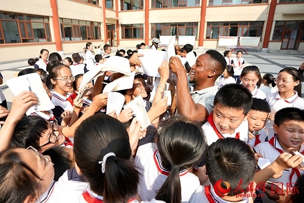 孩子們和選手互動(dòng)簽名。人民網(wǎng) 盧鵬宇攝