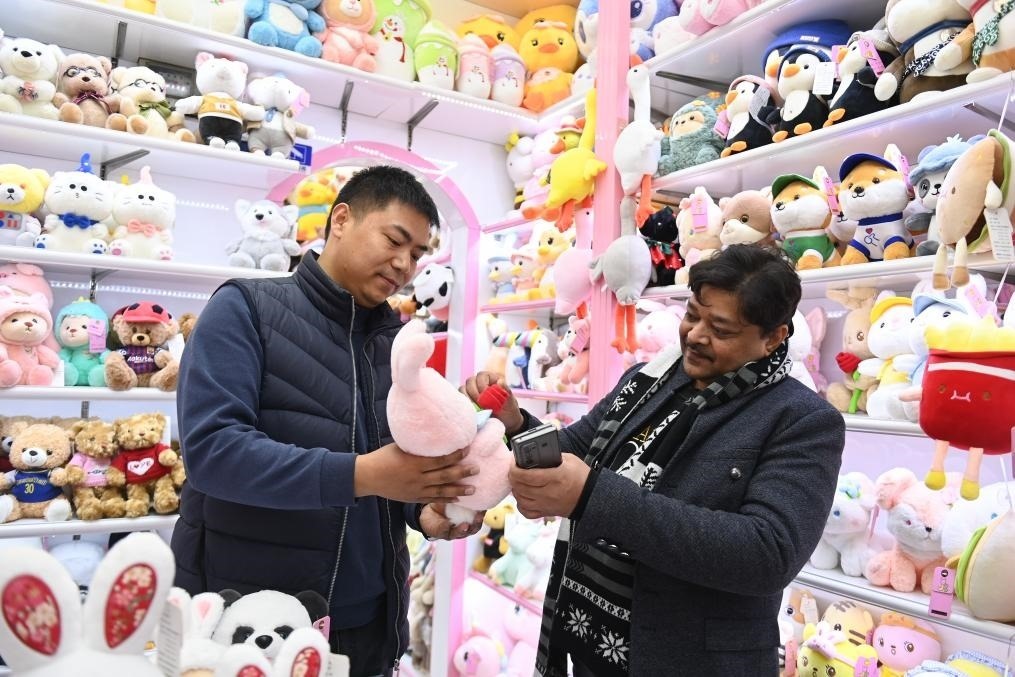 2023年2月2日，來(lái)自印度的客商（右）在義烏國(guó)際商貿(mào)城的一家玩具店鋪內(nèi)選購(gòu)商品。新華社記者 黃宗治 攝