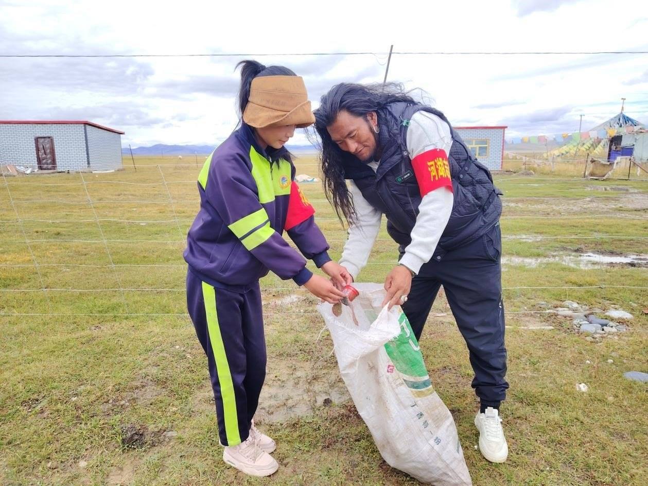玉樹州稱多縣珍秦鎮(zhèn)河湖志愿者才培和他女兒更求拉毛在清掃垃圾。受訪者供圖