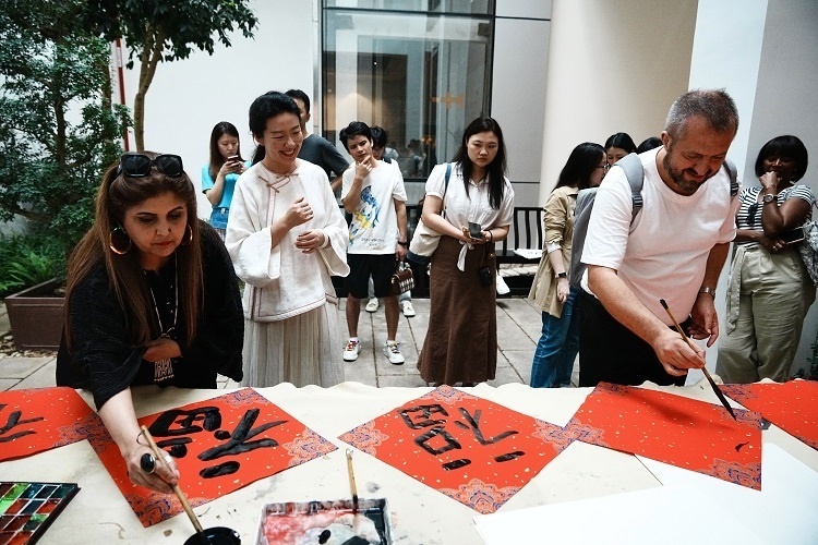 首屆國際傳播“絲路獎”獲獎代表等在廣州市荔灣區(qū)永慶坊參加文化交流活動。楊爍壁、王燕攝影報道
