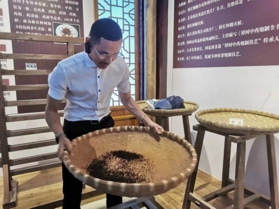 2023“一帶一路”媒體合作論壇聯(lián)合采訪團(tuán)團(tuán)員在非遺文化展示館體驗(yàn)中藥炮制技藝。（本報(bào)記者 黃超攝）