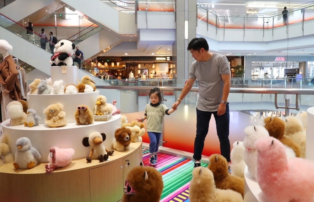 2023年11月2日，顧客在溫暖駝品牌專柜內(nèi)選購。連續(xù)六年參加進(jìn)博會的秘魯羊駝制品品牌溫暖駝在上海市中心商場開設(shè)了專柜。新華社記者 方喆 攝