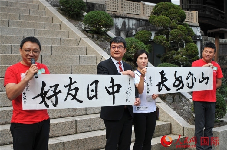 東京中國(guó)文化中心主任羅玉泉展示其為本次活動(dòng)書(shū)寫(xiě)的題詞“中日友好，山高水長(zhǎng)”。人民網(wǎng) 蔣曉辰攝