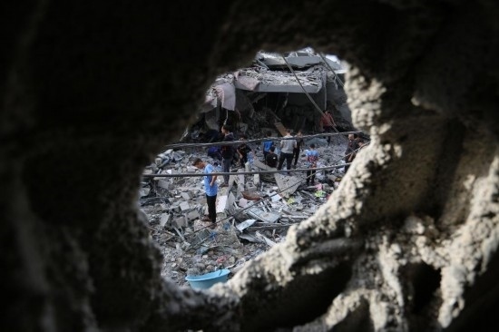 11月11日，在加沙地帶南部城市拉法，人們查看遭以色列襲擊后的建筑。新華社發(fā)（哈立德·奧馬爾攝）