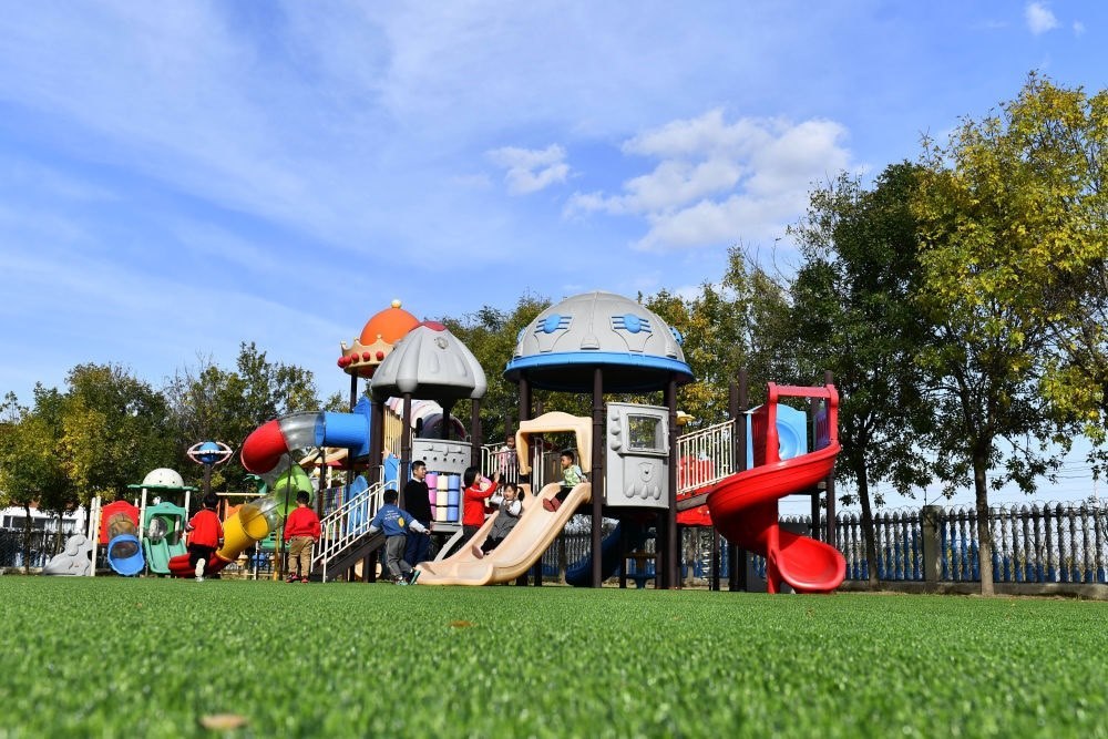 在山東省東營(yíng)市墾利區(qū)楊廟社區(qū)幼兒園，孩子們?cè)诶蠋煹膸ьI(lǐng)下進(jìn)行戶外活動(dòng)（2021年10月19日攝）。新華社記者 郭緒雷 攝