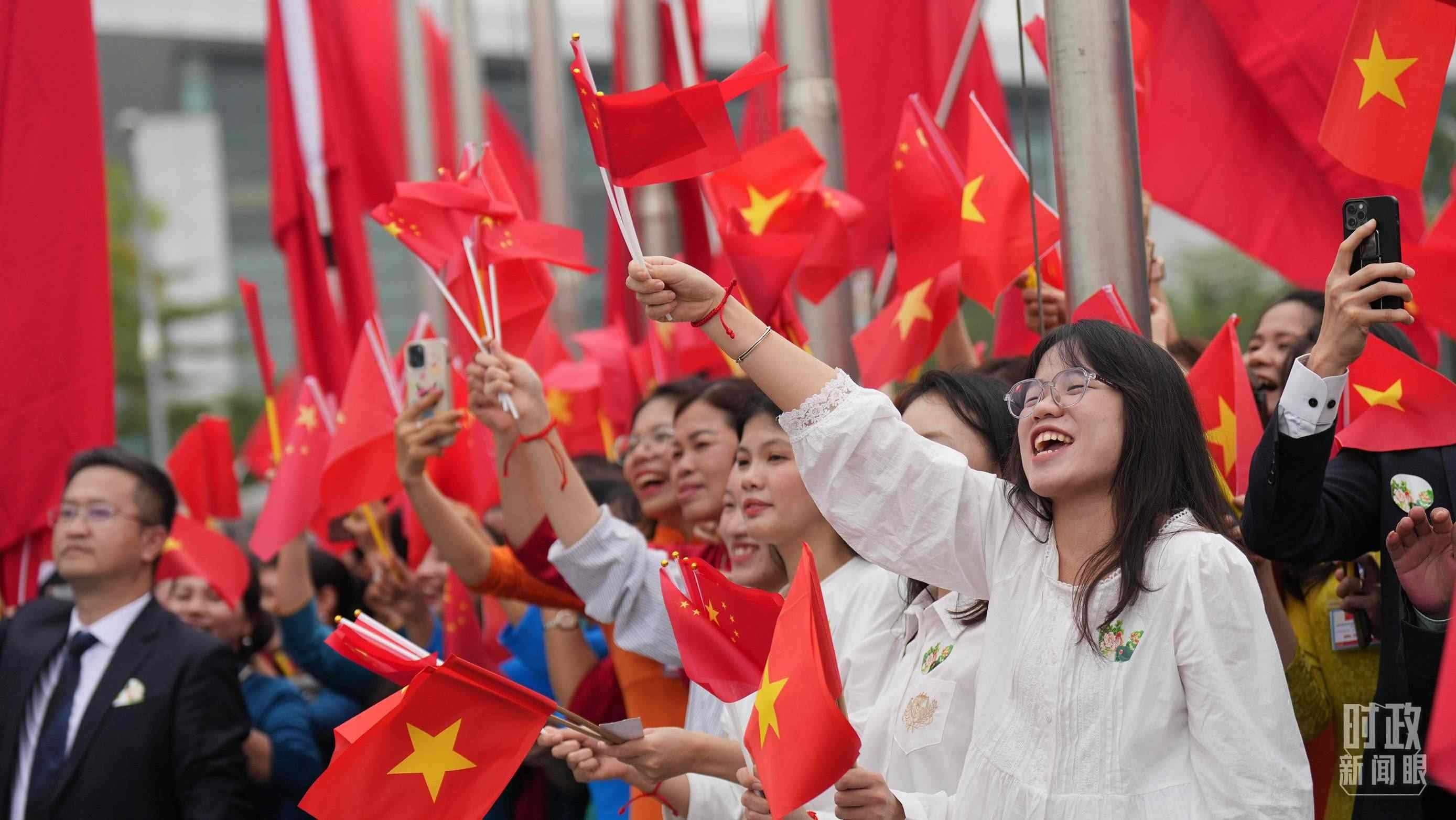 △人們揮舞兩國旗幟歡迎習(xí)近平訪越。（總臺國廣記者李晉拍攝）