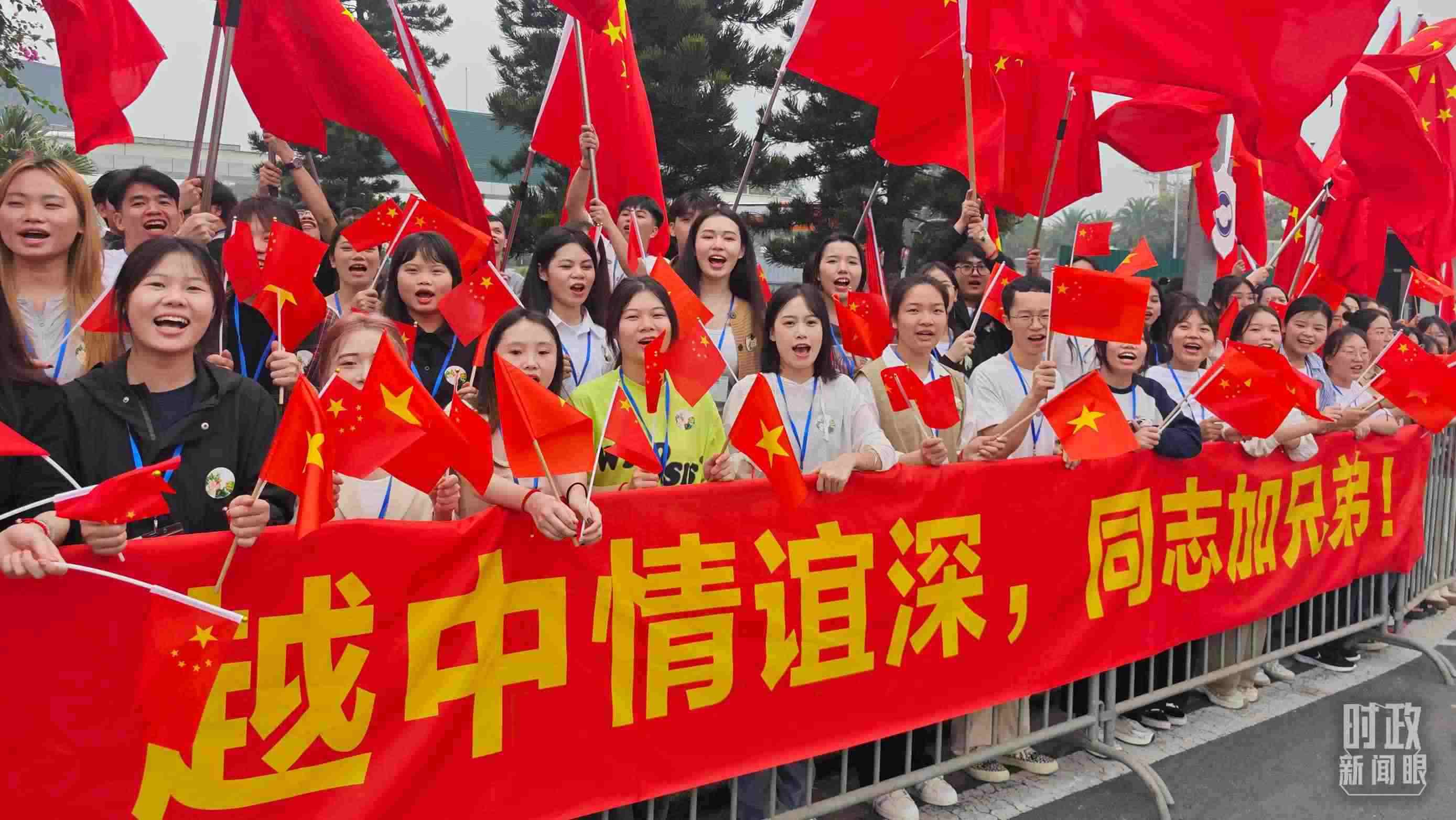 △習(xí)近平乘車從機(jī)場赴下榻飯店途中，許多人自發(fā)聚集在道路兩旁，揮舞兩國旗幟，表達(dá)熱烈歡迎。（總臺央視記者耿小龍拍攝）