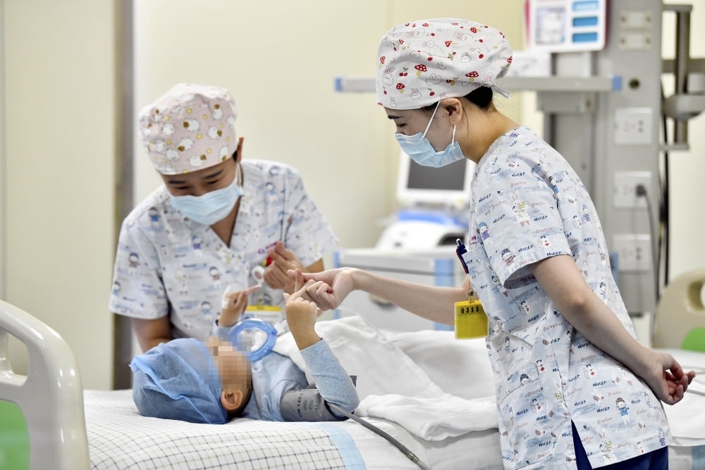 在山東省棗莊市婦幼保健院兒童ICU病房，醫(yī)護(hù)人員為完成靶向治療藥物諾西那生鈉的4歲脊髓性肌萎縮癥患兒加油鼓勁（2022年1月1日攝）。諾西那生鈉注射液是我國(guó)首個(gè)獲批治療脊髓性肌萎縮癥的進(jìn)口藥物，2019年進(jìn)入中國(guó)市場(chǎng)時(shí)，每針價(jià)格近70萬(wàn)元。在2021年國(guó)家醫(yī)保目錄藥品談判中，以3.3萬(wàn)元每針的價(jià)格進(jìn)入新版醫(yī)保藥品目錄。新華社記者 郭緒雷 攝