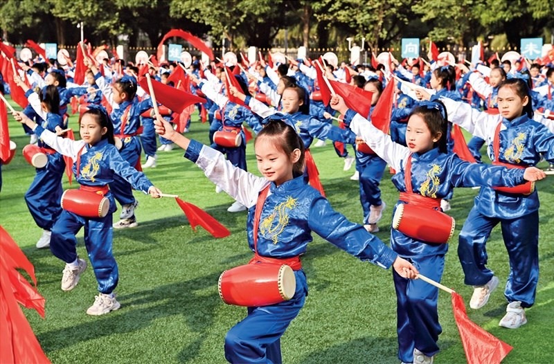 為助推民族地區(qū)基礎(chǔ)教育事業(yè)發(fā)展，廣西重新核定各地中小學(xué)教職工編制，依托全區(qū)編制“周轉(zhuǎn)池”核增事業(yè)編制給各地中小學(xué)，在全面達(dá)到國家標(biāo)準(zhǔn)的基礎(chǔ)上，進(jìn)一步統(tǒng)籌優(yōu)化和動(dòng)態(tài)調(diào)整各區(qū)域、學(xué)校、學(xué)段間編制資源。圖為2023年11月29日，南寧市濱湖路小學(xué)舉行主題為“逐夢(mèng)新時(shí)代 健體向未來”的體育文化節(jié)，孩子們正在跳腰鼓舞。 新華社記者 周華/攝