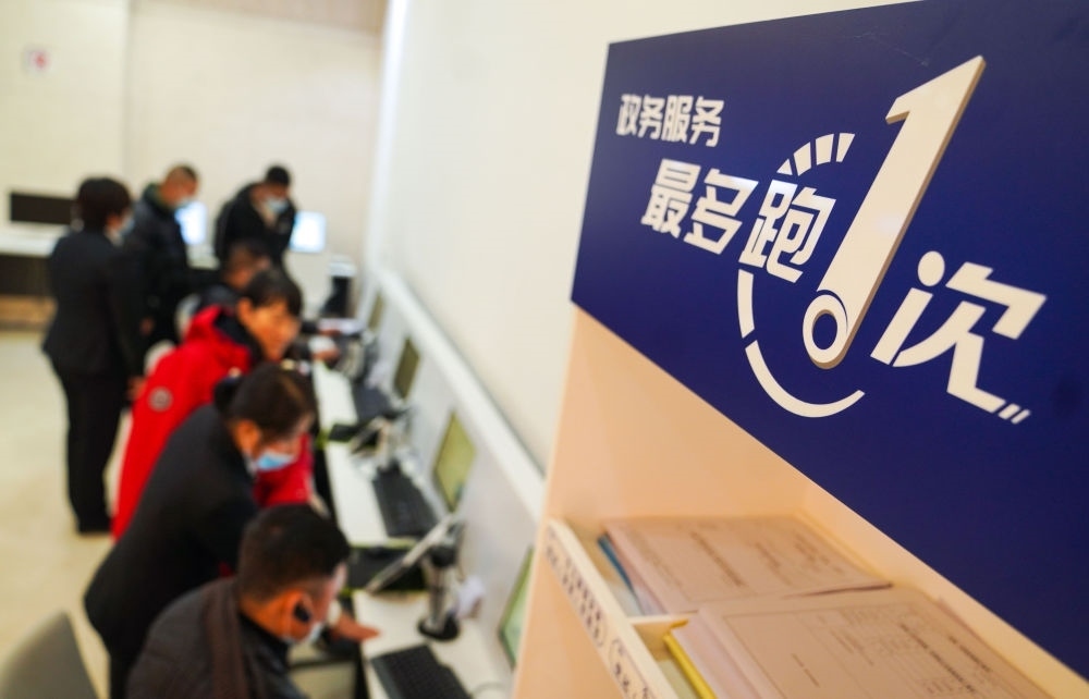 在吉林省長(zhǎng)春市二道區(qū)政務(wù)服務(wù)中心輔助填報(bào)區(qū)，市民在工作人員的輔助下進(jìn)行事項(xiàng)填報(bào)（2020年11月23日攝）。新華社記者 許暢 攝